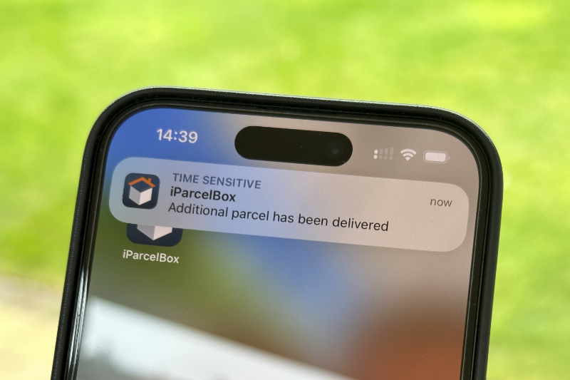 Photo of the customers smartphone showing that an iParcelBox app notification has been received which states 'Additional parcel has been delivered'
