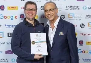 Photo showing iParcelBox founder Paul Needler being handed his #SBS certificate by Theo Paphitis in recognition of our smart parcel delivery box being selected as winners of his Small Business Sunday competition.